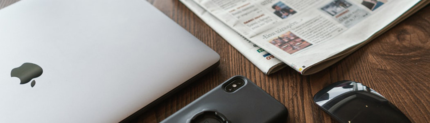 fotografia de un diario, un ordenador y un móvil.